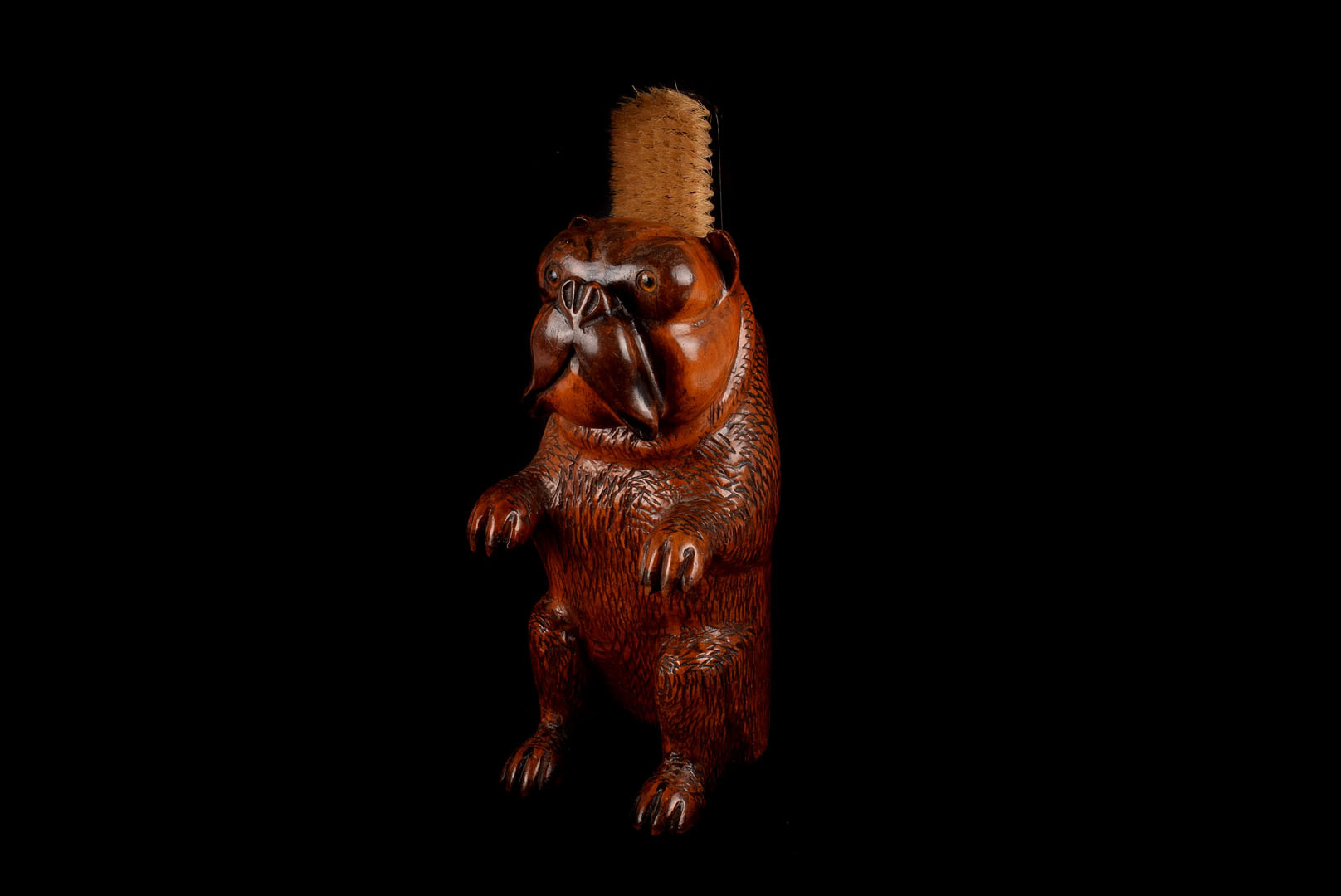A Black Forest style musical clothes brush, modelled as a begging pug, with glass eyes, brush