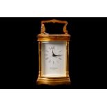 A David Peterson serpentine carriage clock, with bevelled glass and heavy brass case, complete