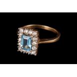 A modern 9ct gold and gem set cluster ring, having a rectangular light blue stone surrounded by