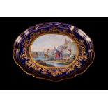 A Sevres serpentine tray, with painted reserve of shell fisherman to a bleu de roi ground, and