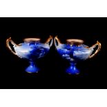 A pair of Children ware Royal Doulton vases, the twin handled vases having images of children to the