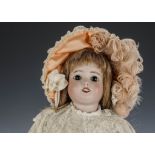 An S.F.B.J. 60 child doll, with fixed dark eyes, auburn hair wig, jointed papier-mâché body, lace