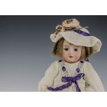 A small Recknagel child doll, with blue fixed blue eyes, hair wig, jointed composition body and