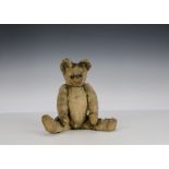 Edward Bear, a British 1920s teddy bear, with blonde mohair, black boot button eyes, pronounced