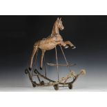 A rare Cheval Bascule wood and cast-iron wheeled rocking horse, circa 1910, with cast-iron head,