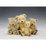 Four plastic nosed Chiltern Hugmee teddy bears, with golden and blonde mohair, orange and black