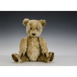 A Chiltern Hugmee musical Teddy Bear, 1950s, with blonde mohair, orange and black glass eyes,