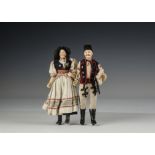 A pair of 19th century German composition dolls, each with blue painted eyes and one heavy brow