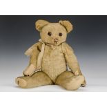 A 1940s Merrythought Teddy Bear, with golden mohair, dark orange and black glass eyes, remains of