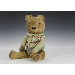 A 1940s British teddy bear, with golden mohair, clear and black glass eyes with remains of brown