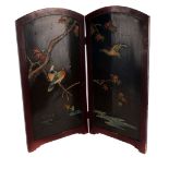 A Japanese lacquered table screen, the two panel folding screen having hand painted bord amongst