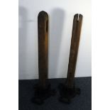 A pair of Art Deco period cast iron and wooden tennis court net posts by Ayres, lacking mechanism,