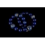 A 20mm graduated Lapis bead necklace, together with a pair of lapis ear pendants. (3)