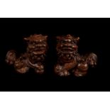 A vintage pair of Chinese bronzed Bhuddist Temple Dogs, each of the dogs of fo stood with a paw on a