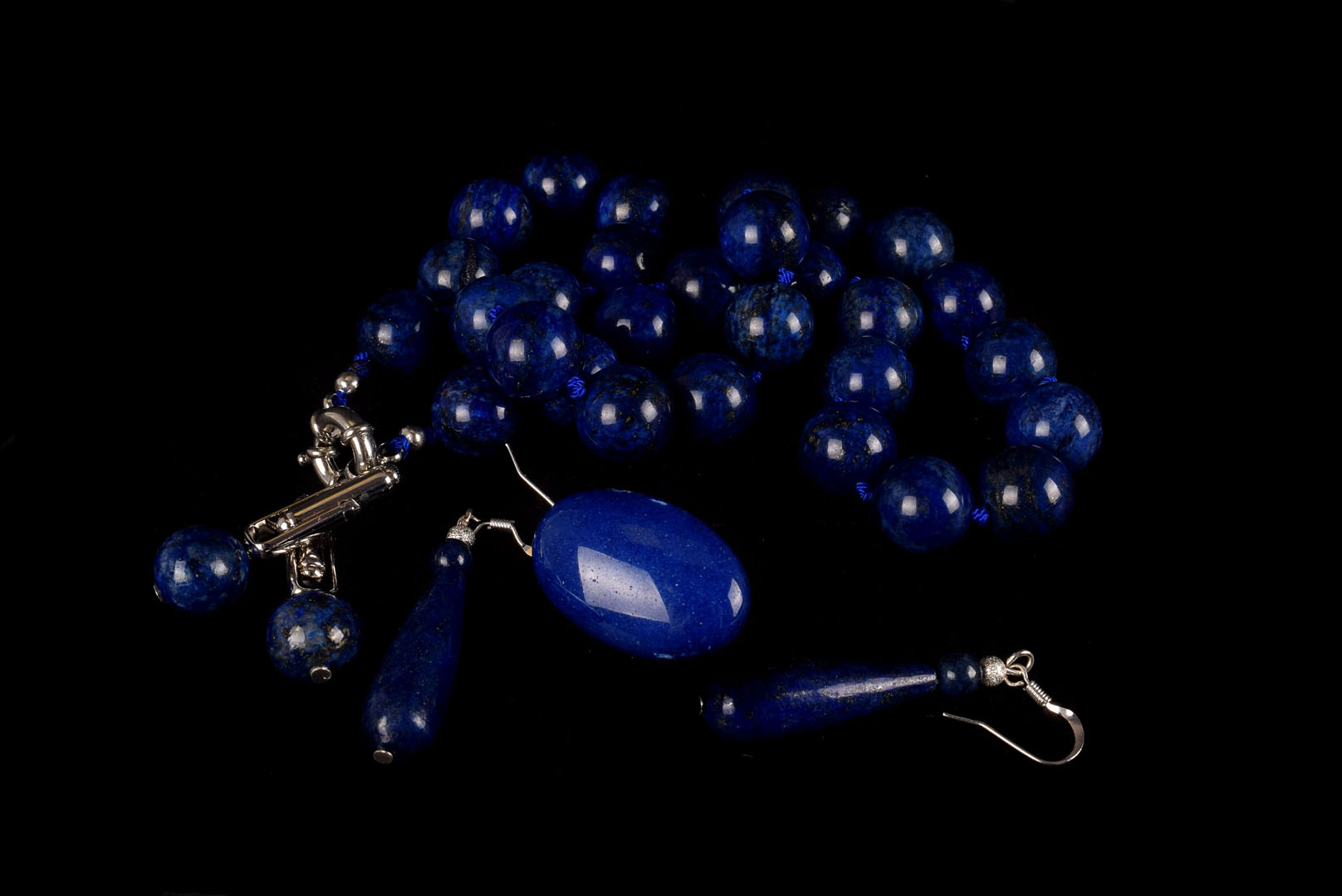 A group of lapis jewellery, including a bead necklace, drop earrings, an oval brooch and a pair of