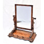 A Victorian mahogany toilet mirror, on shaped base with scroll supports