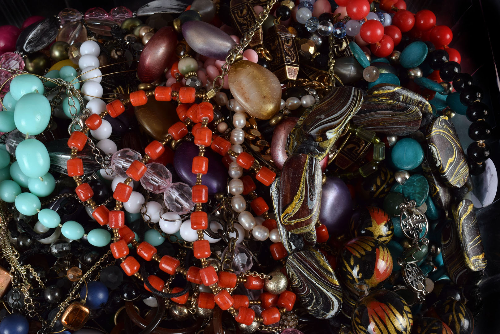 A large collection of costume jewellery, including beads, bangles, a compact, simulated pearl