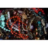 A large collection of costume jewellery, including beads, bangles, a compact, simulated pearl