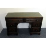 A 1950s stained beech desk, pedastal style with two drawers to frieze, and two drawers to each