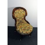 A Victorian walnut nursing chair, having floral and bird upholstered seat and back, on casters