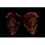 A pair of walnut wall brackets, the carved female head with Art Nouveau style floral decoration