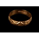 An 18ct gold band, having repeatative geometric engraved design, approx 2.8g