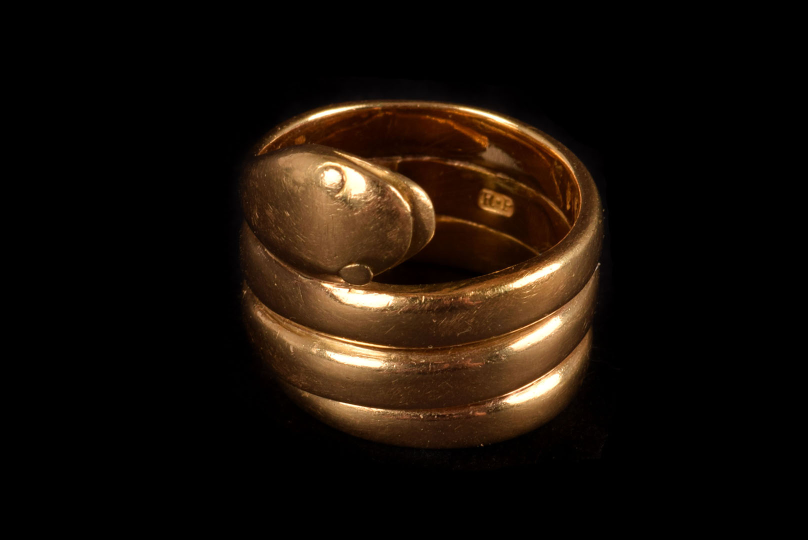 An 18ct gold serpent ring, marked Sheffield, by R.P, the serpent design winding round the finger,