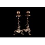 A pair of silver plated serpent and flower bud candlesticks with lily pad decortation over webfooted