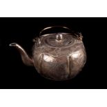 An Art Deco period Chinese white metal tea pot, having panels of flowers and inscription, strike