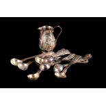 A George III silver cream jug and a set of nine mustard spoons, the small embossed jug dated
