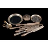 A set of six continental silver knives, possibly French, together with a silver Aspreys jam pot lid,