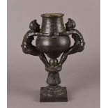 A 19th century bronze Roman style bronze twin handled vase, having waisted bowl supported by two