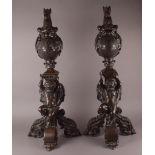 A pair of large 19th century bronze andirons, each cast with the crest of gryphon head surmounting a