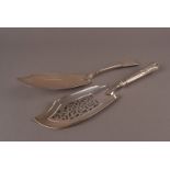 Two 19th century silver fish slices, one a George III fiddle pattern example dated London 1803,