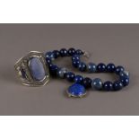 A modern associated suite of lapis lazuli jewellery, including a large white metal cuff bangle, a