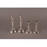 Two pairs of modern silver filled candlesticks, both with plain spreading bases, one pair taller,