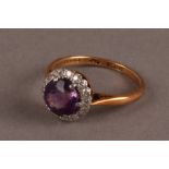 A modern 18ct gold and gem set cluster ring, having circular purple stone surrounded by small