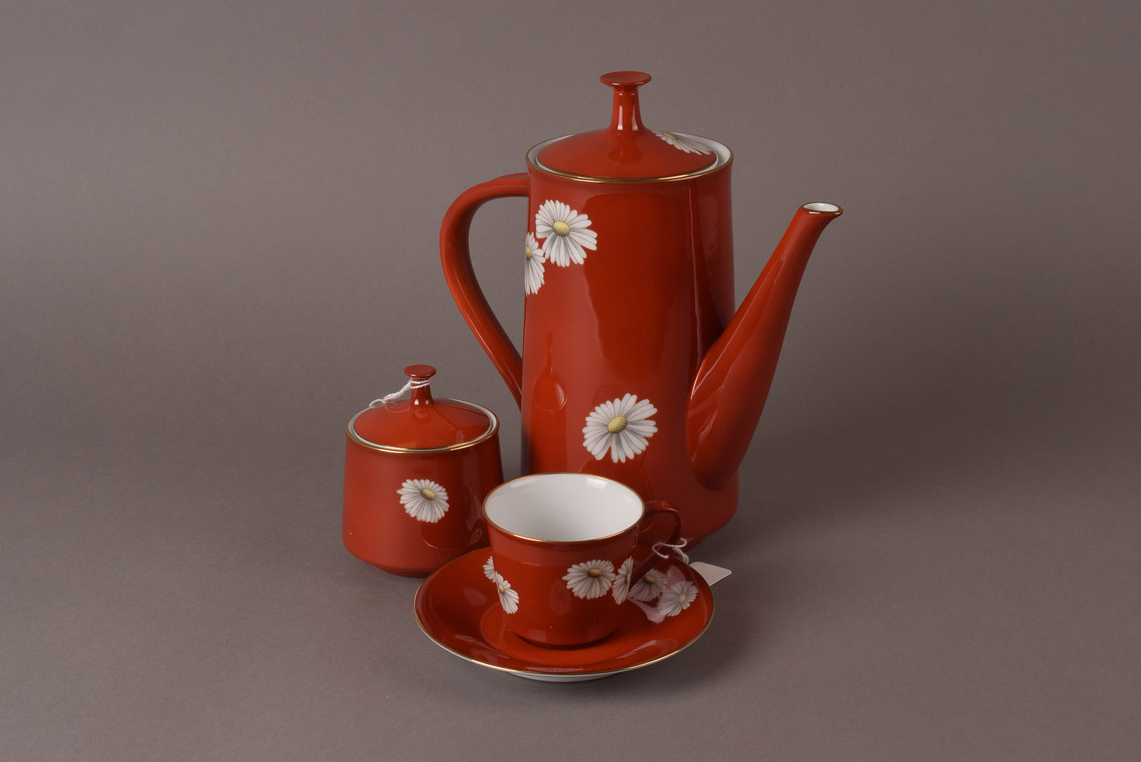 A Noritake porcelain coffee set, having red ground with daisy decoration, comprising six cups and