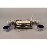 A pair of George V silver peppers, of cylinder shape with pierced design, blue glass linners, also