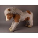 A large vintage Merrythought toy pony, in white and brown, with fluffy mane, bearing label, kindly