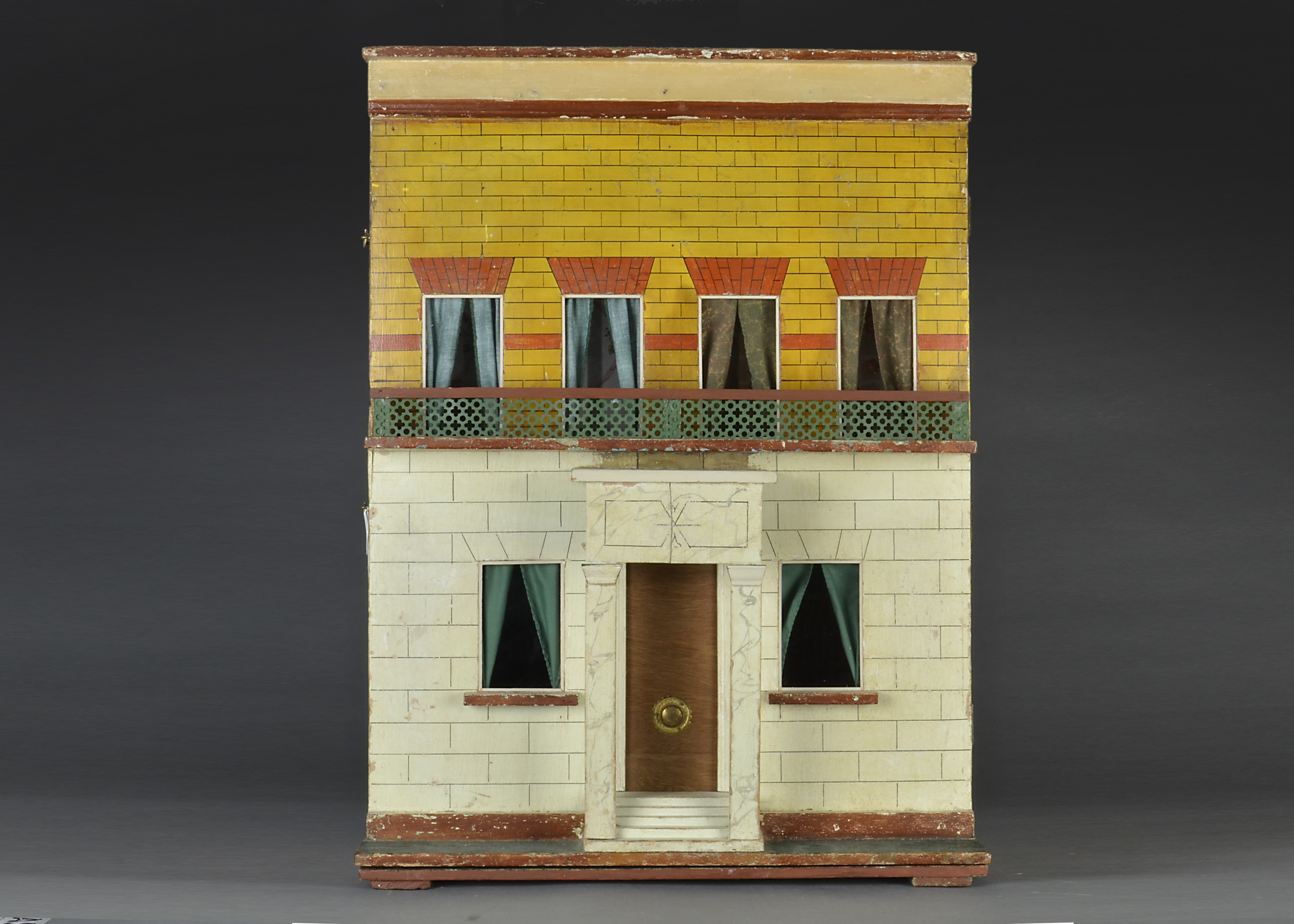 A Silber & Fleming type box back dolls’ house, with stone and yellow brick painted façade, red brick