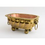 BAROQUE STYLE REPOUSSÉ BRASS JARDINIÉRE The oval everted reeded rim above a lobed bowl fitted with