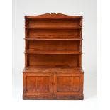 VICTORIAN MAHOGANY STANDING BOOKCASE With an undulating top rail above four graduating shelves and