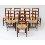 SET OF EIGHT ENGLISH BEECHWOOD LADDER-BACK CHURCH CHAIRS Each fitted with a rush seat. 32 1/2 x 14