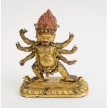 NEPALESE GILT-BRONZE FIGURE FIGURE OF A MULTI-ARM DEITY The three-faced head with flaming