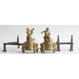PAIR OF LOUIS XIV GILT BRONZE FIGURAL CHENETS Each modeled as a cherub seated on rockwork or clouds,