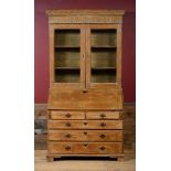 GEORGE III PINE BUREAU BOOKCASE With an overhanging dentil molded cornice above a pair of glazed