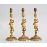 THREE NAPOLEON III STYLE GILT-METAL FIGURAL CANDLESTICKS, MOUNTED AS LAMPS