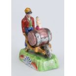 WOODS TYPE CREAMWARE FIGURE OF A BOY PUSHING A KEG ON WHEEL BARROW