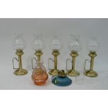 A collection of five brass lanterns with glass sha